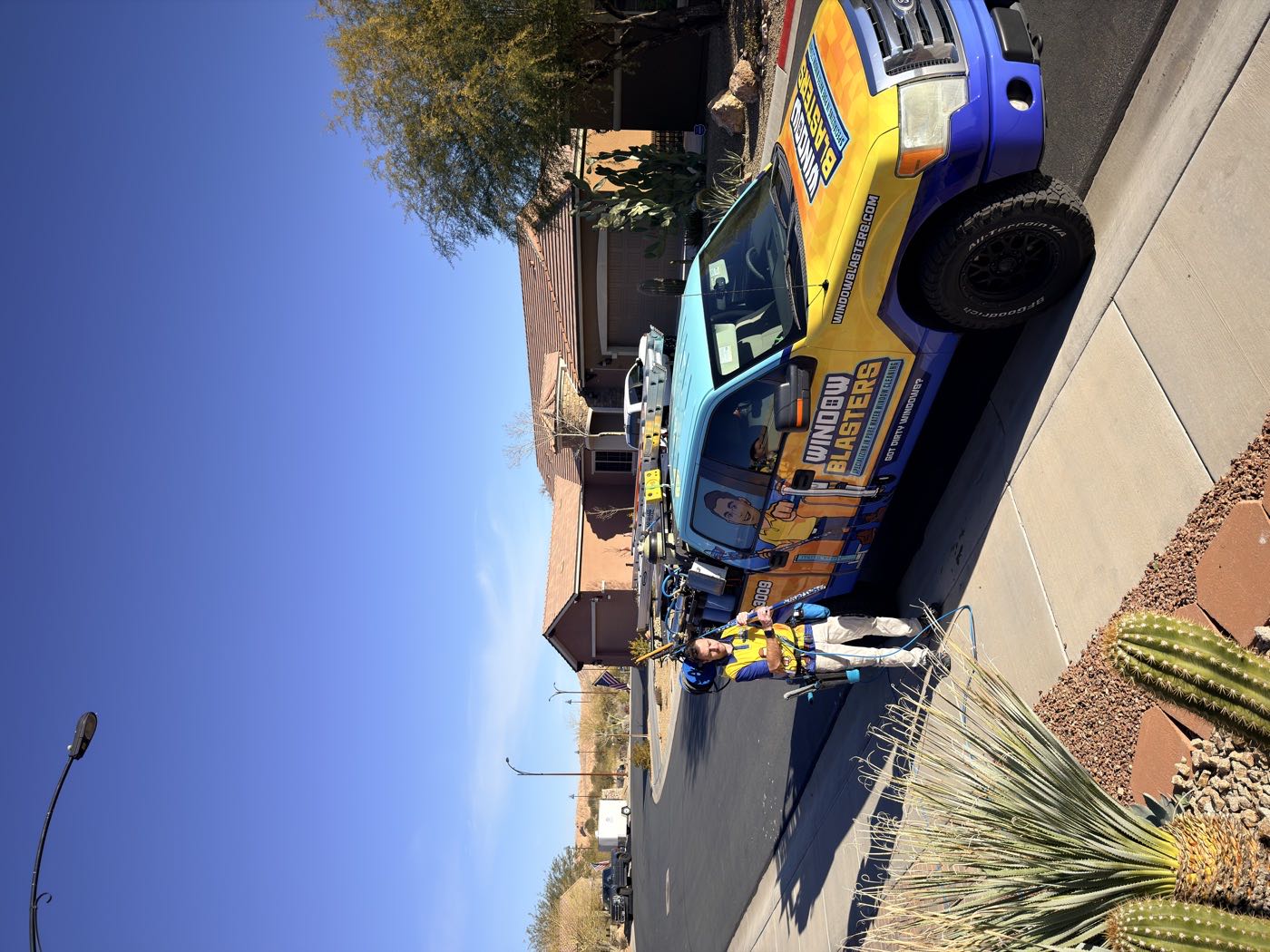 A Window Blasters technician cleaning a home's exterior glass
