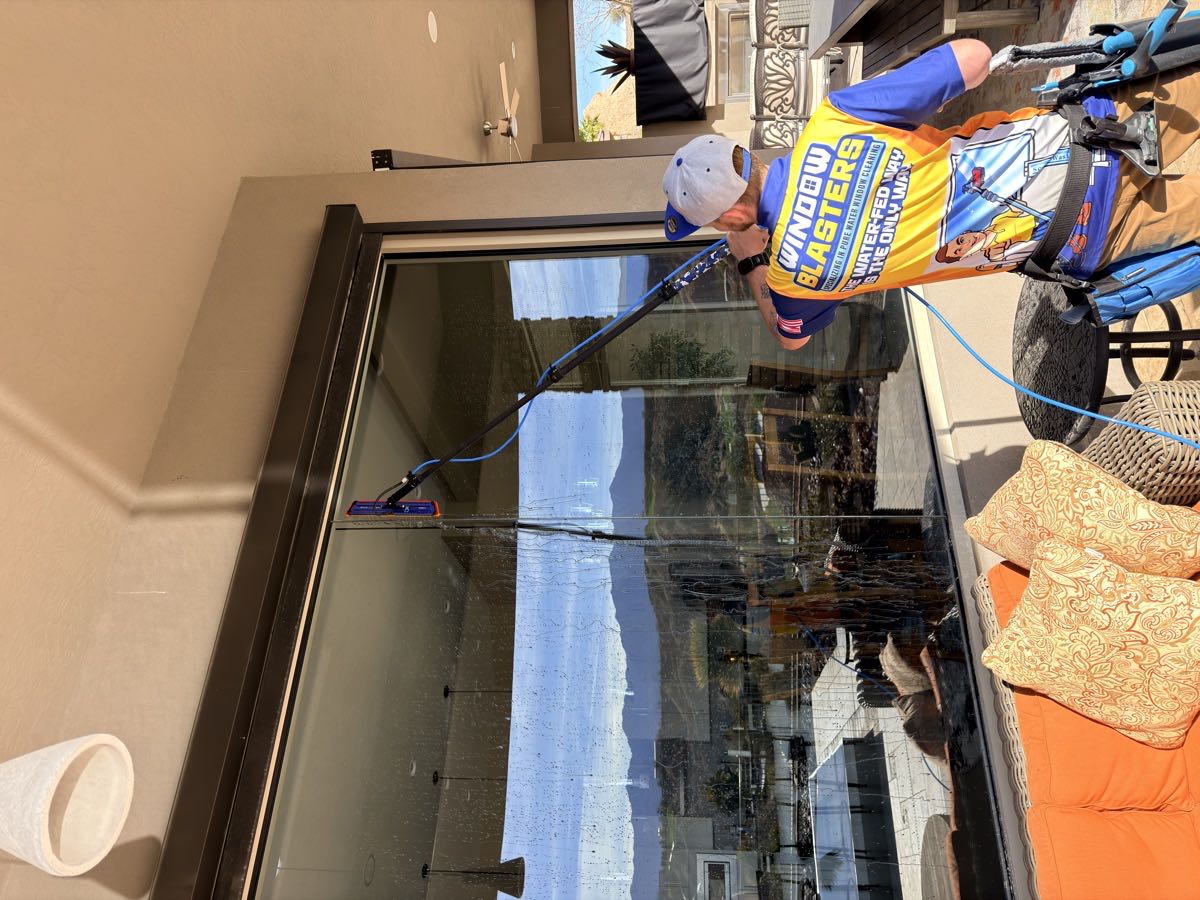 Interior window cleaning with a view of the red rock hills