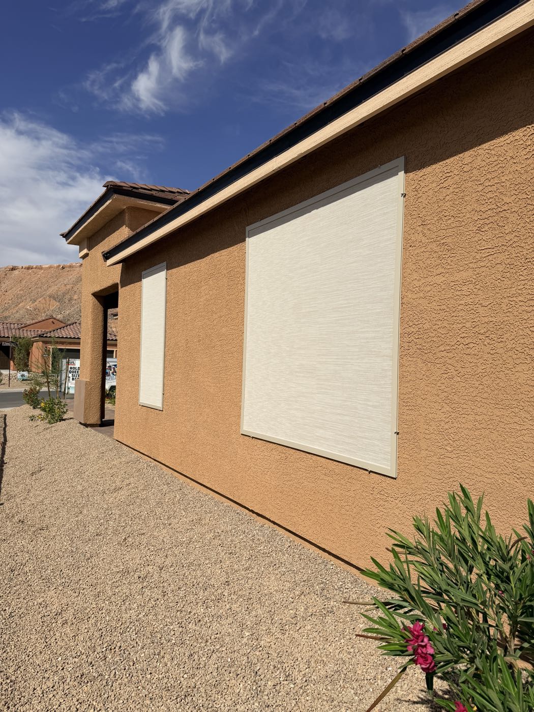 A front elevation with new solar screens under a bright blue desert sky