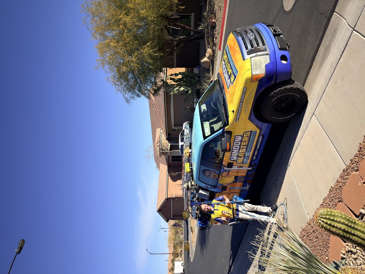 A Window Blasters technician beside the company's wrapped work truck
